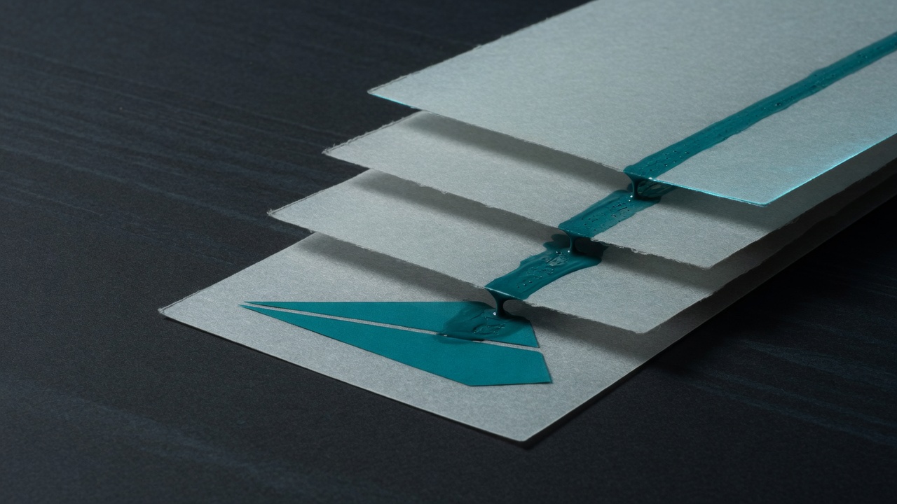 Four offset mineral-paper planes on a dark ground, a teal channel running through them. No people.